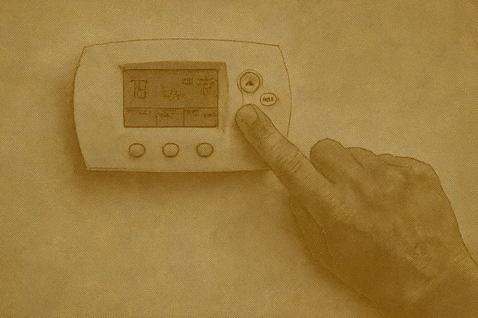 Hand adjusting a digital thermostat on a wall, symbolizing smart temperature control and energy-efficient heating in a Canadian home.