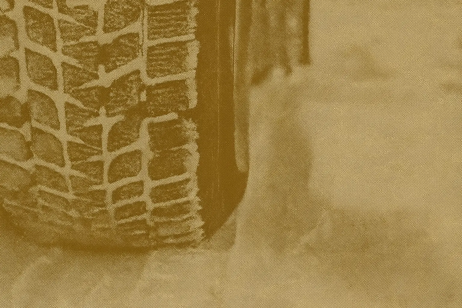 Close-up of a winter tire tread packed with snow showing deep grooves and ice-grip sipes for Canadian winter driving