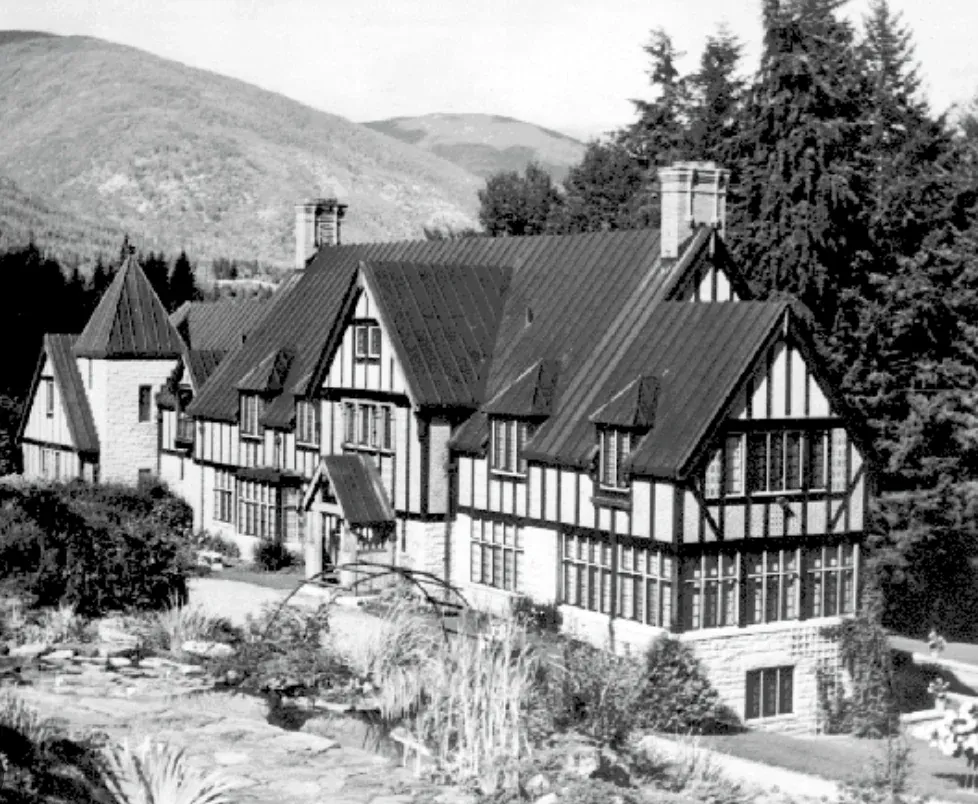 Blaylock Mansion exterior with Tudor Revival style and mountain backdrop.
